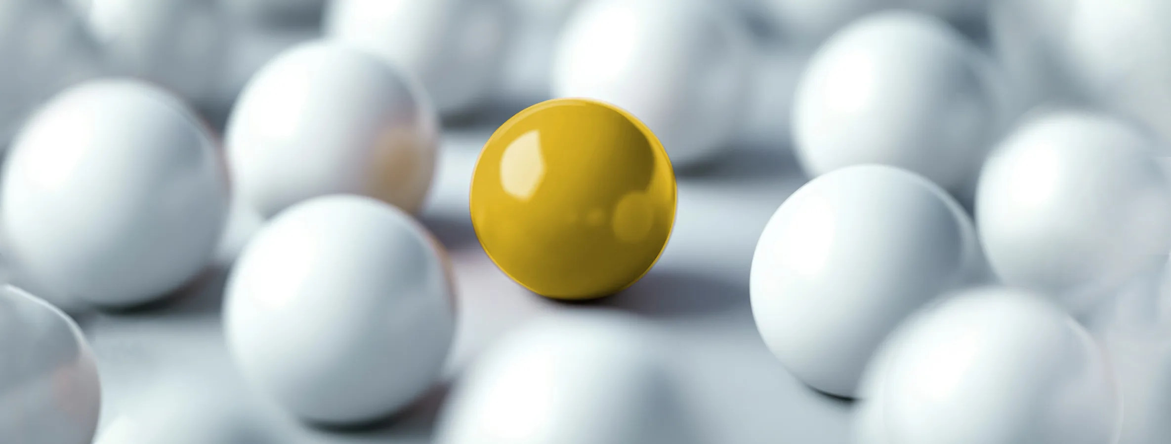 Eine goldene Kugel hebt sich zwischen weißen Kugeln ab – Symbol für digitale Sichtbarkeit und Differenzierung im Online-Marketing von Be1Eye.